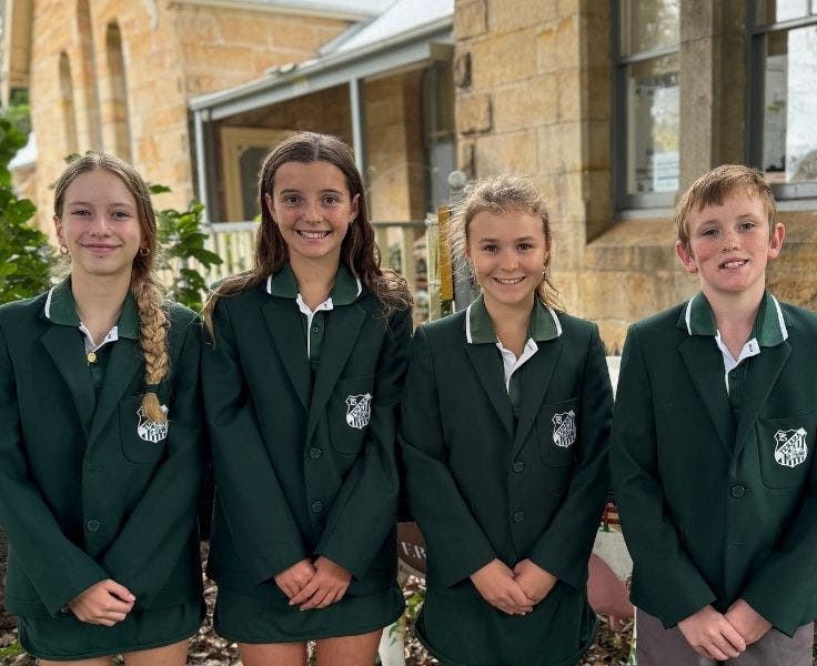 Our school leaders standing in front of the school building.