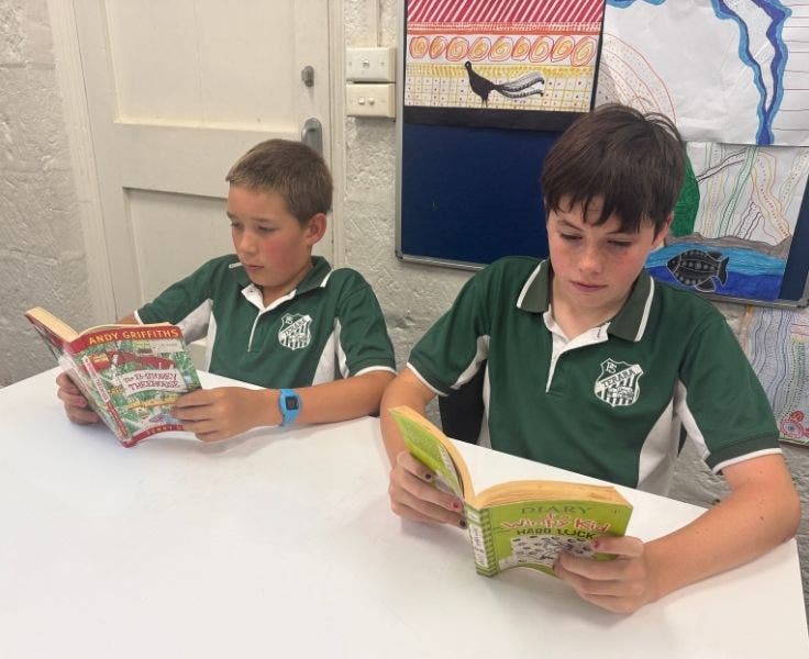 Two students reading novels.