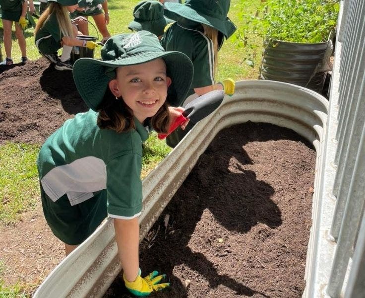 Student digging in the garden.