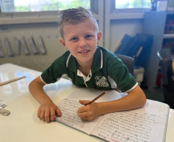 Student sitting at a desk writing.