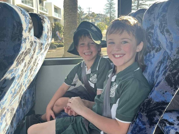 Two children travelling on a bus.