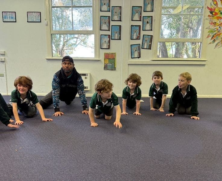 A group of kindergarten students dancing with Uncle Dale.