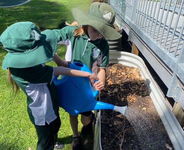 Two students watering the garden.